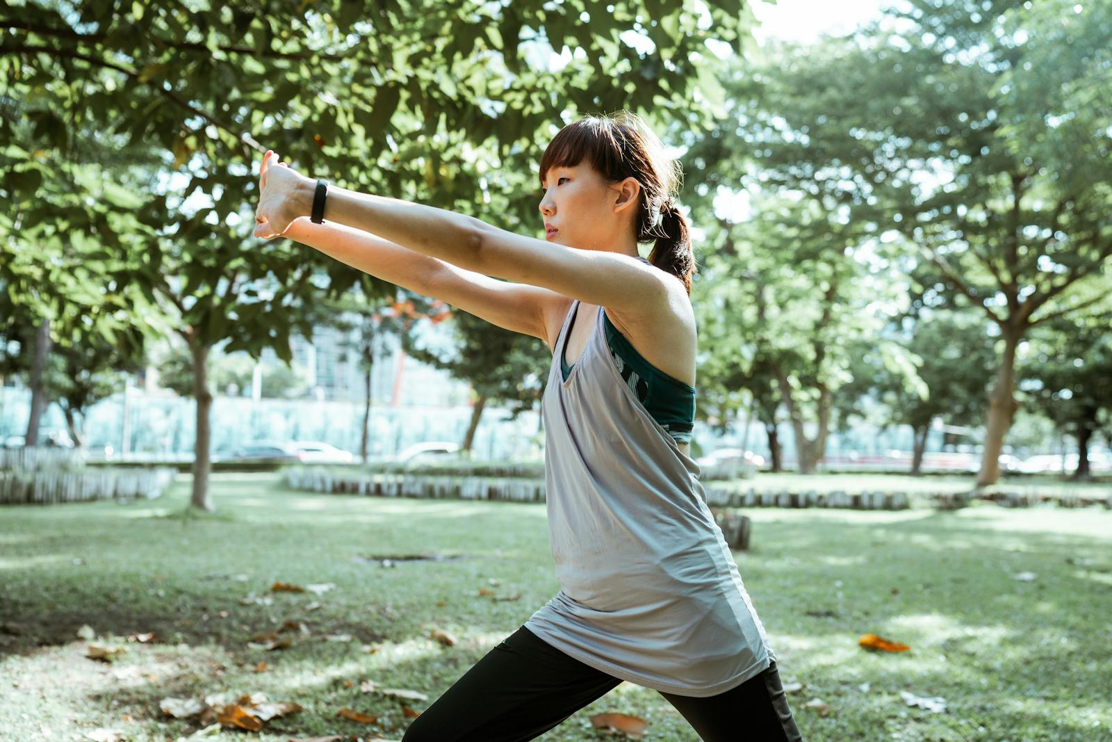 Runner stretching outdoors in a green park before or after exercise