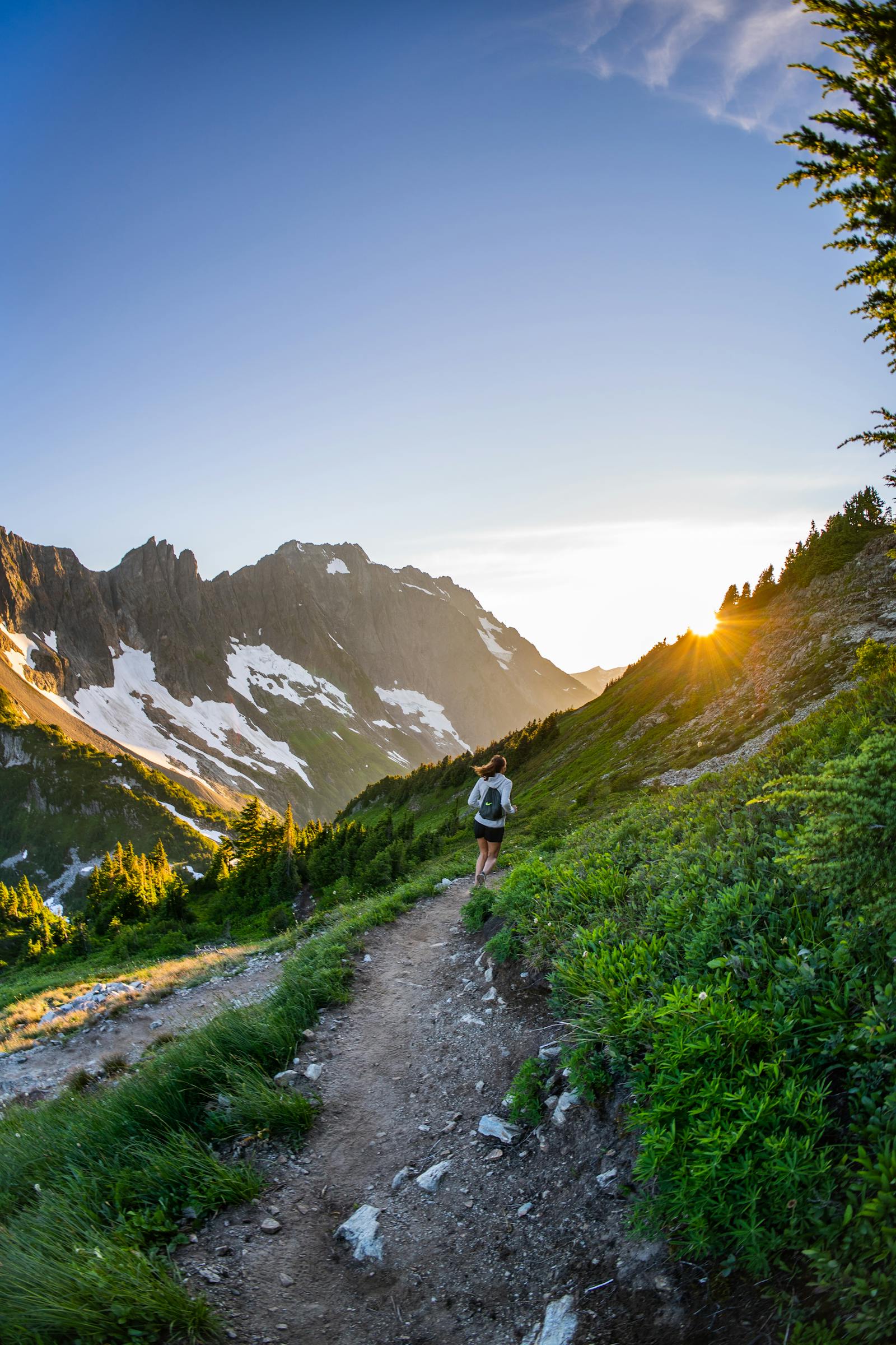 Runner heading uphill on a scenic mountain trail